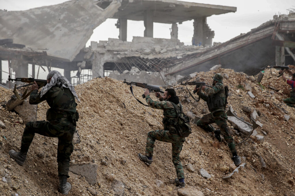FILE - Syrian army soldiers fire their weapons during a battle with rebel fighters at the Ramouseh front line, east of Aleppo,…