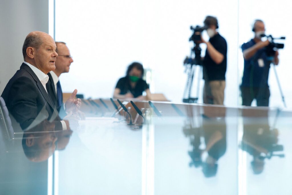 German Chancellor Olaf Scholz is reflected in glass as he addresses a press conference on current domestic and foreign policy…