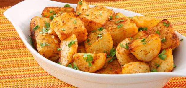 طبق تقديم على شكل قارب به مكعبات بطاطس في الفرن مزينة بالبقدونس المفروم